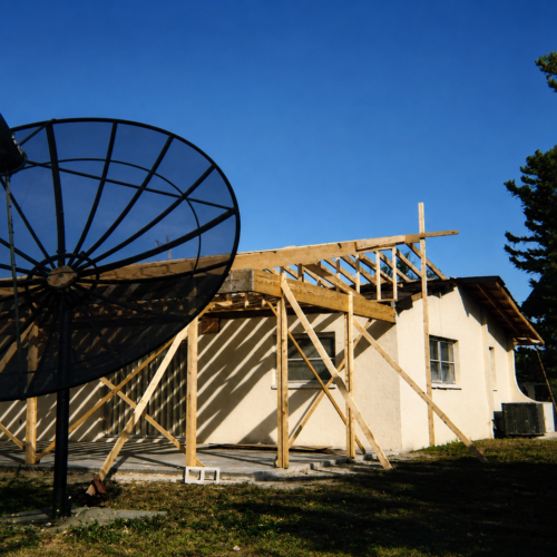 Project Archive addition construction site with satellite dish and tree.webp