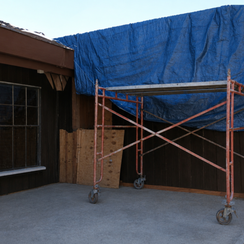 Project Archive addition construction site with scaffolding and tarp.webp