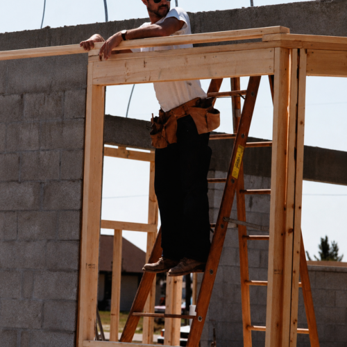 Tom DePaola was known as an expert framer. worker on ladder at construction site
